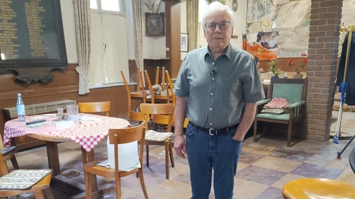 Hermann Hermsen, ein älterer Herr in Hemd und Jeans, steht in der alten Wacholderbrennerei