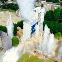 Ein weißes Hochhaus stürzt nach einer geplanten Sprengung ein
