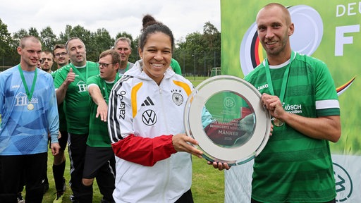 Fußballerinnen wird de Meisterplakette überreicht