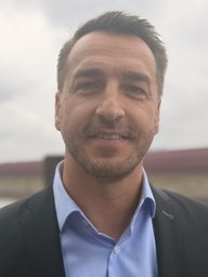 Ein Mann in Anzug steht am Hafenbecken des Rheins