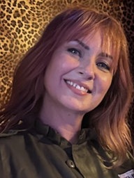 Frau mit roten Haaren lächelt in die Kamera