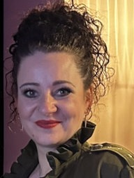 Frau mit dunklen Haaren lächelt in die Kamera