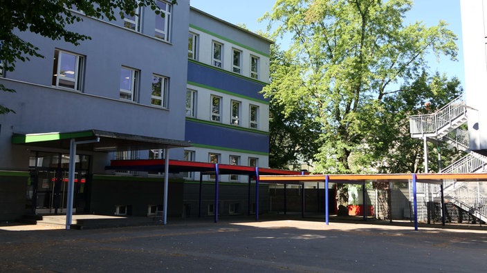 Ein Hinterausgang mit teilüberdachtem Schulhof.