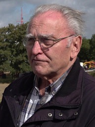 Älterer Mann mit grauen Haaren und Brille blickt an Kamera vorbei.