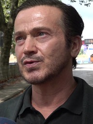 Mann spricht und schaut an Kamera vorbei