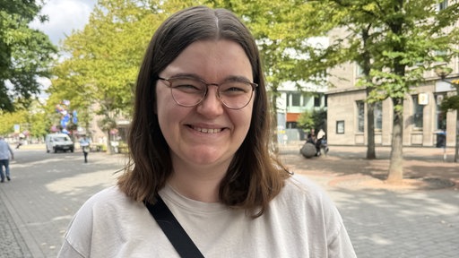 Sofie Mühlbacher lächet in die Kamera im Hintergrund ist die Duisburger Innenstadt zu sehen.
