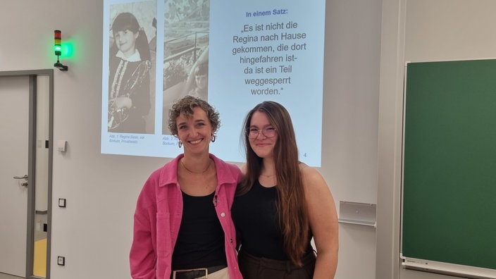 Die zwei Studentinnen Olivia Wroblewski und Zoe Hüls stellen in ihrer Präsentation ihre Ergebnisse des Interviews vor