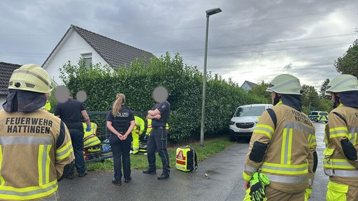 Einsatzkräfte der Polizei und der Feuerwehr am Tatort in einem Hattinger Wohngebiet.