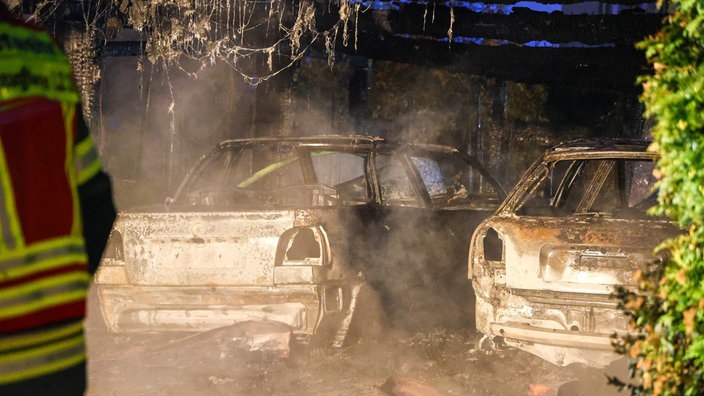 Die ausgebrannten Autos stehen unter dem Carport