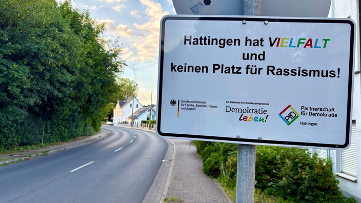 Straßenschild "Hattingen hat Vielfalt und keinen Platz für Rassismus", darunter die Symbole von "Demokratie leben" und "Partnerschaft für Demokratie"