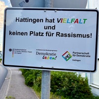 Straßenschild "Hattingen hat Vielfalt und keinen Platz für Rassismus", darunter die Symbole von "Demokratie leben" und "Partnerschaft für Demokratie"
