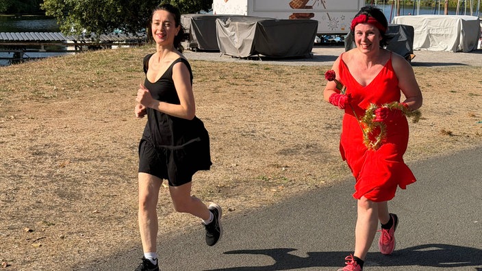 Zwei Frauen joggen in Abendgarderobe