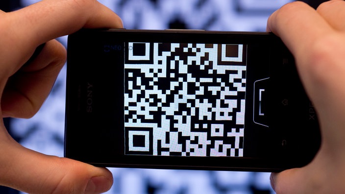 Zwei Hände, die ein Handy halten, das einen QR-Code scannt.