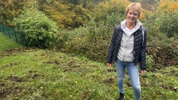 Heike Steimann-Monse steht auf einer von Wildschweinen verwüsteten Wiese.