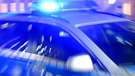 Das Bild zeigt einen Polizeiwagen mit Blaulicht.