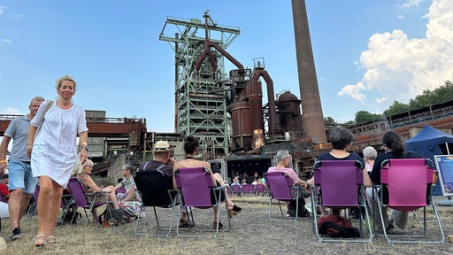 Zahlreiche Zuschauer sitzen inmitten der alten Industrieanlage in Hattingen und schauen zum Showprogramm auf der Bühne.