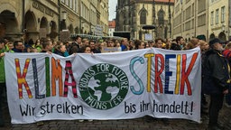 Schüler halten ein Banner mit der Aufschrift "Klimastreik"