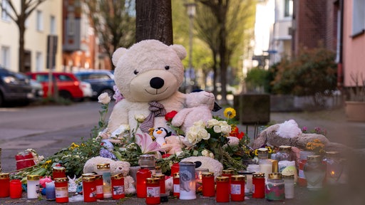 Viele Menschen haben Kuscheltiere, Blumen und Kerzen an den Ort der Tat gesammelt.