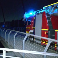 Ein Feuerwehrfahrzeug mit Blaulicht steht im Dunkeln auf der Brücke über den Rhein-Herne-Kanal in Gelsenkirchen
