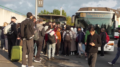 An einer Bushaltestelle am Gelsenkirchener Hauptbahnhof drängen sich viele Menschen, um in einen Bus des Schienenersatzverkehrs zu kommen
