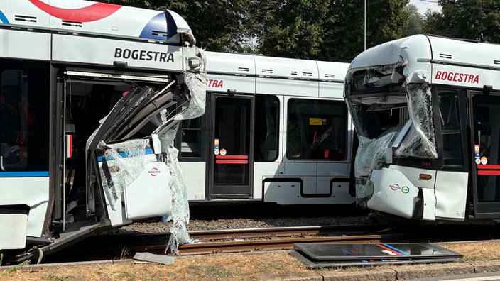 Die beiden am Unfall beteiligten Straßenbahnen stehen schwer beschädigt am Unfallort