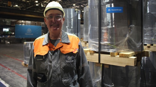 Dietmar Schäfer steht vor verpacktem Elektroband.