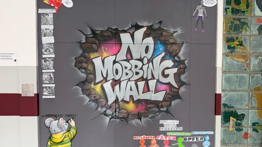 Ein buntes Graffiti gegen Mobbing auf einer Wand
