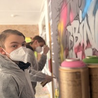 Schüler sprühen ein Graffiti