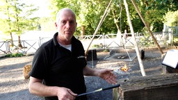 Michael Schepers steht an einem öffentlichen Grillplatz im Wald an der Sechs-Seen-Platte.