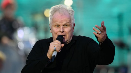 Musiker Herbert Grönemeyer mit einem Mikrofon in der Hand