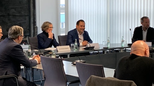 Bauministerin und Hagens Oberbürgermeister sitzen mit anderen Menschen an einem großen Tisch