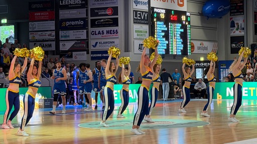 Cherleaderinnen von Phoenix Hagen feuern mit goldenen Puscheln während einer Spielunterbrechung an