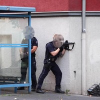 Polizisten an einer Hauswand. Einer hält eine Maschinenpistole im Anschlag.