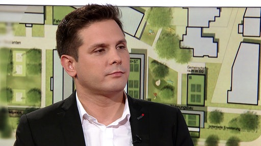 Mann mit grauen kurzen Haaren steht in Redaktion.