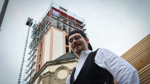 Ein junger Mann steht vor der Sankt Elisabeth-Kirche in Hagen