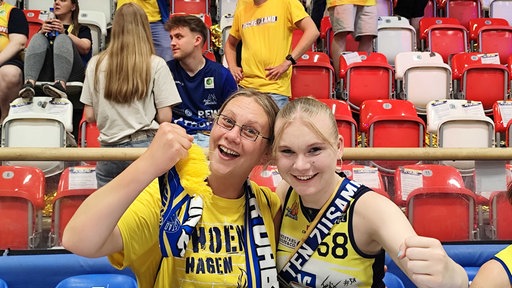 Zwei blonde Frauen mit Fanutensilien von Phoenix Hagen jubeln in die Kamera.