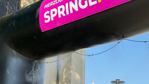 Pinkes Schild mit Aufschrift Herzlich Willkommen zum Springefest