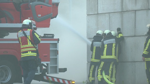 Vier Feuerwehrmänner löschen den Brand.