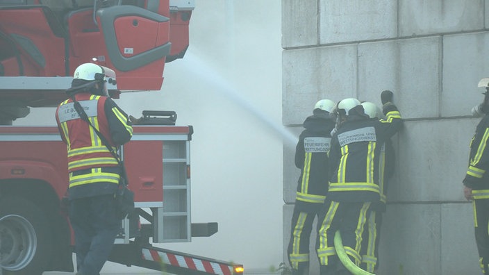 Vier Feuerwehrmänner löschen den Brand.