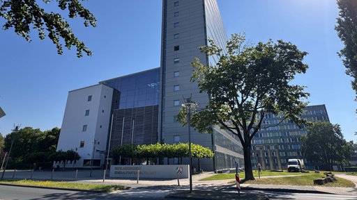 Ein halb graues und halb verglastes modernes Gebäude, davor ein Schild mit der Aufschrift "Oberlandesgericht Generalstaatsanwaltschaft".