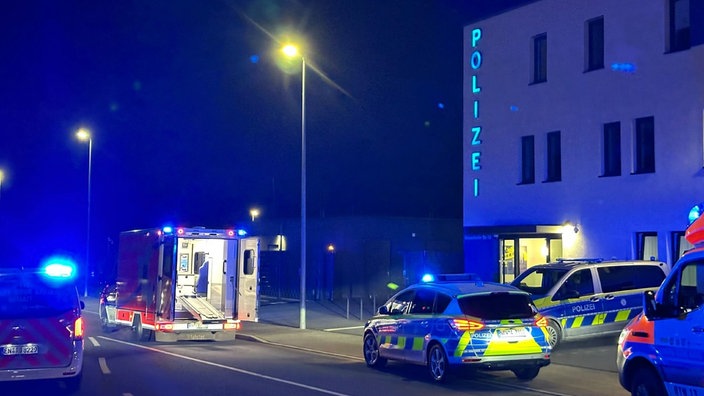 Polizeiautos und ein Krankenwagen stehen im Nachtlicht vor einer Polizeiwache in Hattingen