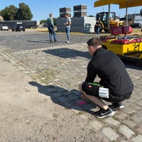 Eine Fläche auf dem Kirmesplatz wird mit dem Maßband ausgemessen.