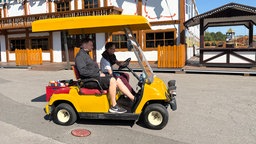 Der Platzmeister fährt mit einem Golfkart über den Kirmesplatz
