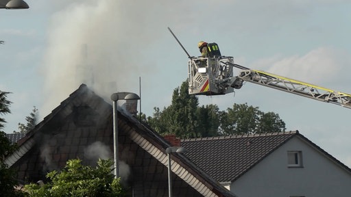 Feuerwehrleute bekämpfen den Brand im Dachstuhl.