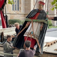 Mehrere Männer laden die Statue von Kardinal Hengsbach vor dem Essener Dom auf einen Anhänger.