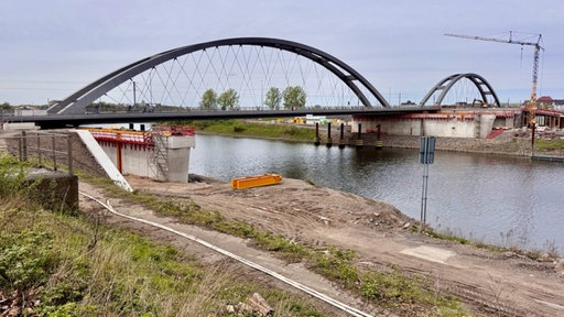 Man sieht eine Brücke und einen darunter herfließenden Fluss.