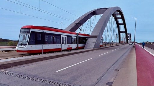 Man sieht eine Brücke, über die gerade eine Straßenbahn fährt.