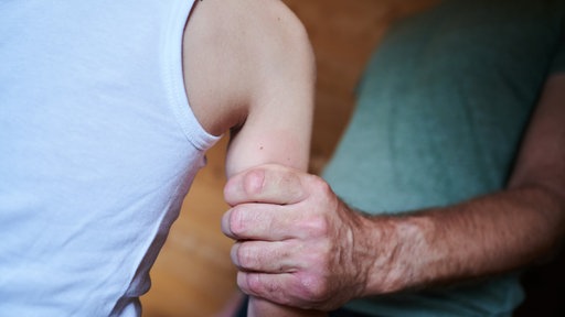 Ein Mann hält ein Kind fest am Arm