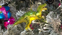 Eine grüne Weihnachtskugel in Dino-Form