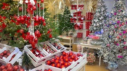 Mehrere Kisten voller roter Weihnachtskugeln liegen in einem Geschäft